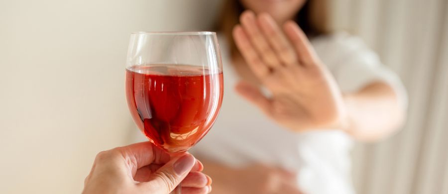 Janeiro seco: uma pessoa oferece uma taça de vinho e uma outra recusa mostrando a palma da mão